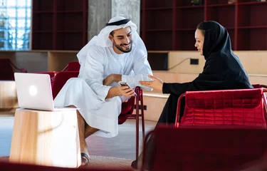 Gardinen handsome man and woman with traditional clothes working in an office of Dubai © oneinchpunch