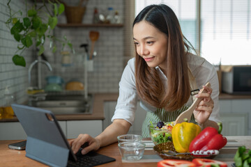 Asian housewife cutting fresh vegetables mixing salad ingredients cooking tasty vegan meal look...
