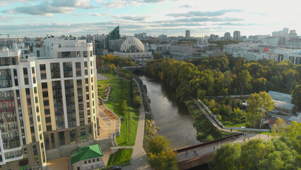 Fototapeta na wymiar Top view of beautiful park area in center of modern city. Stock footage. Beautiful green park with river in center of city. Well-maintained park in center of modern city with stylish architecture