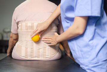 Physiotherapist massage back patient women with ball at hospital,Physical therapy concept