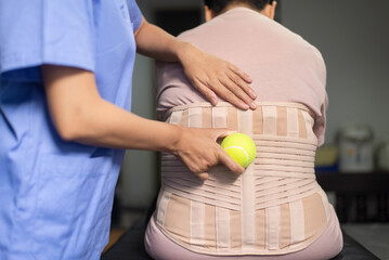 Physiotherapist massage back patient with ball at hospital,Physical therapy concept