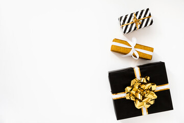 Christmas composition. Christmas gifts, black and golden wrapping paper on white background