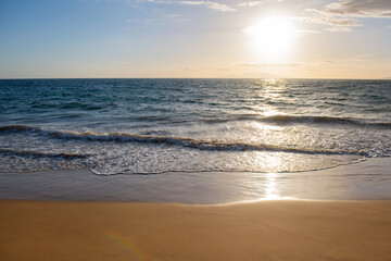 Naklejka na ściany i meble Sunset. Blue ocean wave on sandy beach. Beach in sunset summer time. Beach landscape. Tropical seascape, calmness, tranquil relaxing sunlight.