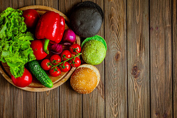 Top view of three colorful hamburger buns with vegetables. Black, green, yellow buns. Copy Space