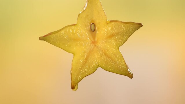 Slow Motion Macro Shot of Flowing Carambola Juice from Halved Carambola Star Fruit