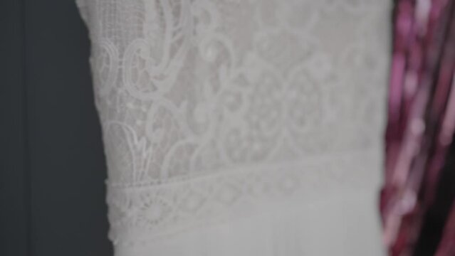 close-up video shooting of beautiful lace patterns on a wedding dress that hangs on a coat hanger