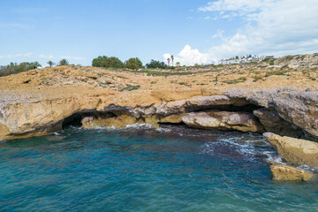 Fototapeta na wymiar Sea caves on the rocky coast of Cyprus. Rocky shore broken by waves.