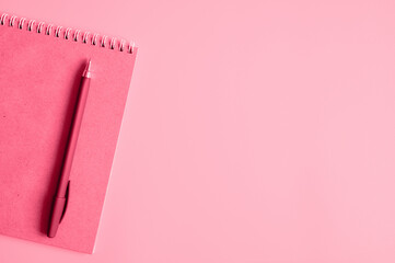 notebook or sketchbook made of craft paper and a pen on a pink background. mockup and space for...
