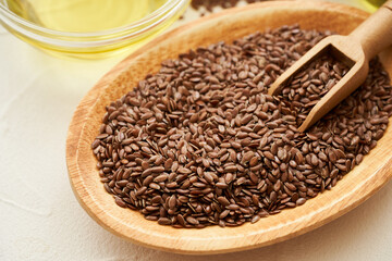 flaxseed linseed oil in wood bowl on white table background. close up flaxseed linseed oil. flaxseed linseed oil                                                   