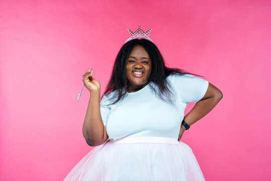 Image of a beautiful woman posing in a fairy costume on a pink background