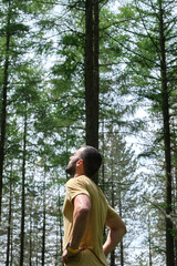man breathes fresh air in the forest, catching a ray of sunshine