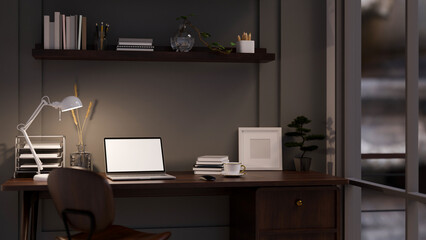 Modern dark office working space at night with laptop mockup, office supplies and decor on table