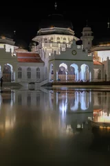 Deurstickers The night atmosphere at the Baiturrahman Grand Mosque. Reflection of the Baiturrahman Grand Mosque building at night. Banda Aceh. © Fani