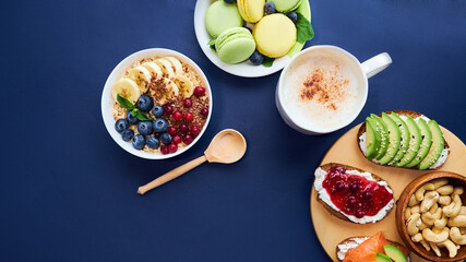 breakfast top view black background. oatmeal with berries, toasts on a wooden tray, nuts, coffee