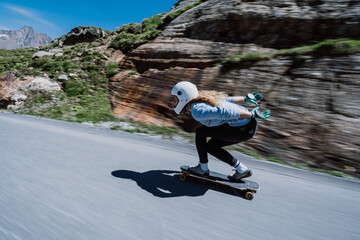 Cinematic downhill longboard session. Young woman skateboarding and making tricks between the...