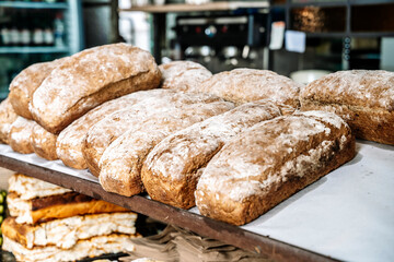 Loaves of bread on the shelves of the shop bakery counter. Fresh, homemade wheat and whole grain breads and pastries.