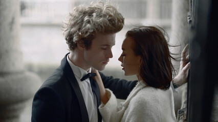 Young bride and groom posing in a city on a windy day. Action. Young woman in white dress and a man...