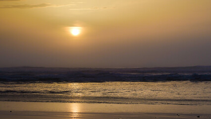 Coucher de soleil chaleureux sur la plage de Moliets-et-Mâa, par un temps couvert, en période hivernale