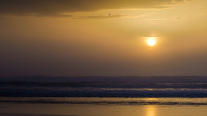 Naklejka premium Coucher de soleil chaleureux sur la plage de Moliets-et-Mâa, par un temps couvert, en période hivernale