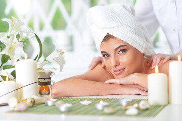 young woman relaxing during massage in spa salon