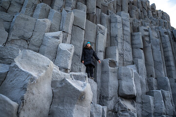 posing woman is indulging  on basaltic rock at Reynisfjara black Beach