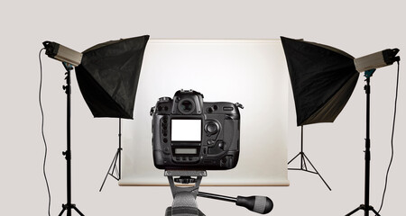 Black camera on tripod in photo studio.
