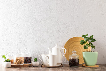 the kitchen background of a modern countertop. coffee pot with mugs, glass eco-jars with cane...