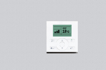 Room thermostat on wall. Modern digital thermostat on beige background with copy space. Save heating concept.