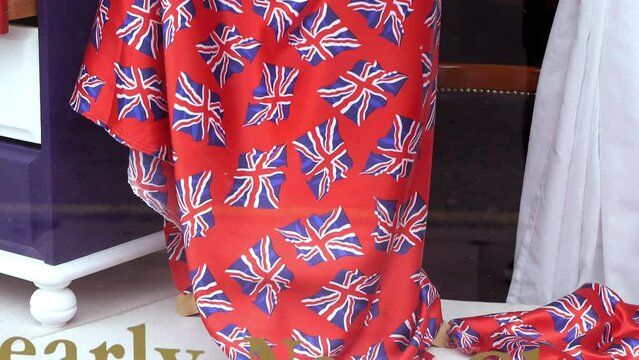 red women's dress in a shop window on the dress there are flags of England all over the dress in small format design 