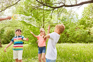 Fototapeta premium Children enjoying while playing with soap bubble