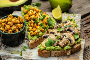 toast with avocado, roasted chickpeas and mushrooms on a dark background. superfood concept. Healthy, clean eating. Vegan or gluten free diet