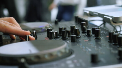 Fototapeta na wymiar Close-up of man playing on dj console. Media. Man turns buttons on music console. DJ plays new music console at disco