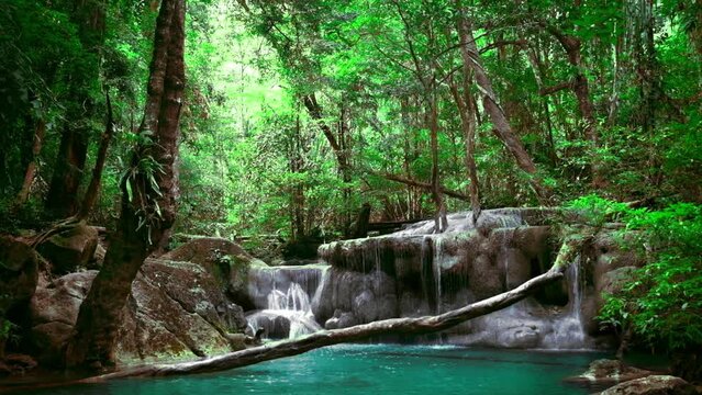 Jungle landscape with flowing turquoise water of Erawan cascade waterfall at deep tropical rain forest. Erawan National Park, Kanchanaburi, Thailand