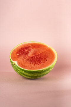 half of slice of watermelon on rose soft background 