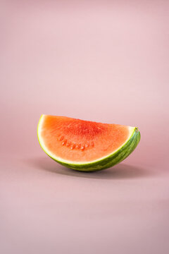 half of slice of watermelon on rose soft background 