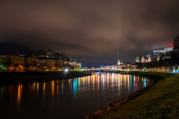 Fototapeta premium Night view of Salzburg across River Salzach, Austria