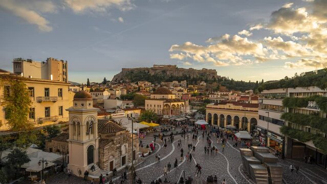 Athens, Greece - December 2nd 2022: Time lapse of Monastiraki square from sunset into blue hour with illuminated Akropolis landmark in the background 