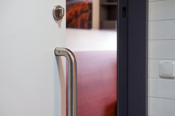 Nahaufnahme einer Schiebetür eines barrierefreien Badezimmers mit Blick in den Raum und auf Möbel, selektiver Fokus