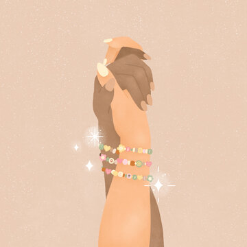 two multi ethnic girls holding hands wearing friendship bracelets on beige background