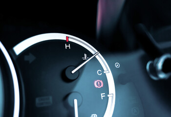 Temperature gauge indicator on car instrument panel and caution light illuminated, automotive part concept