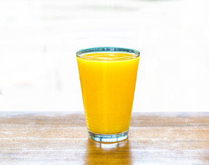 orange juice in clear glass white background