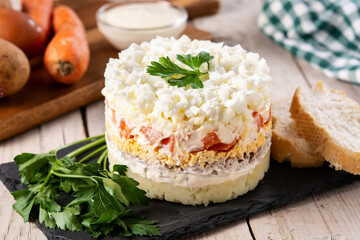 Russian salad or Olivier salad for Christmas dinner on wooden table