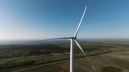 Scenic aerial view of wind turbines farm in daytime. Shot. Beautiful windmills, blue cloudy sky and farm fields.