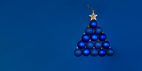 Christmas background with gold and blue balls decorated as tree on dark blue. Merry christmas...