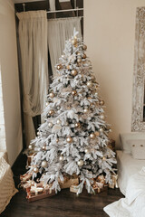 A beautiful Christmas tree in a decorated living room with a bed. Festive interior.Christmas