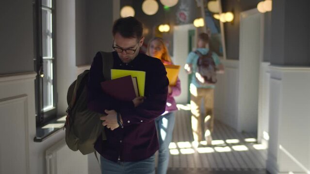 Upset university student walking alone after classes bullied by classmates. Realtime