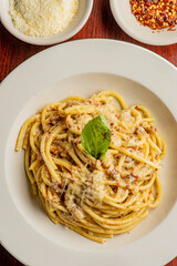 Spaghetti carbonara. Pasta with cured pork, cheese, egg, bacon, pepper and Italian parsley. Classic American or Italian restaurant favorite. Homemade pasta with butter sauce, meat and cheese.
