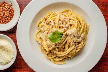 Spaghetti carbonara. Pasta with cured pork, cheese, egg, bacon, pepper and Italian parsley. Classic American or Italian restaurant favorite. Homemade pasta with butter sauce, meat and cheese.