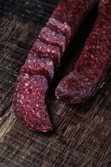 Cutting smoked sausage on wood background