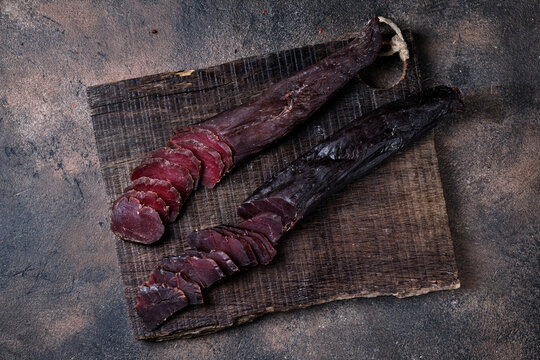 Two Piece Of Homemade Jerky Meat On A Kitchen Cutting Board